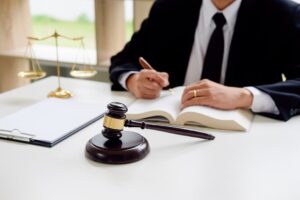 A judge's gavel with justice lawyers holding a team meeting in the background, symbolizing concepts of law and legal practice.