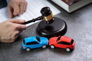 A judge hitting a gavel on a table surrounded by cars. 