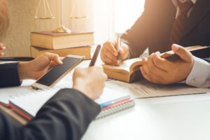 The hard work of an asian lawyer in a lawyer's office. Counseling and giving advice and prosecutions about the invasion of space between private and government officials to find a fair settlement.