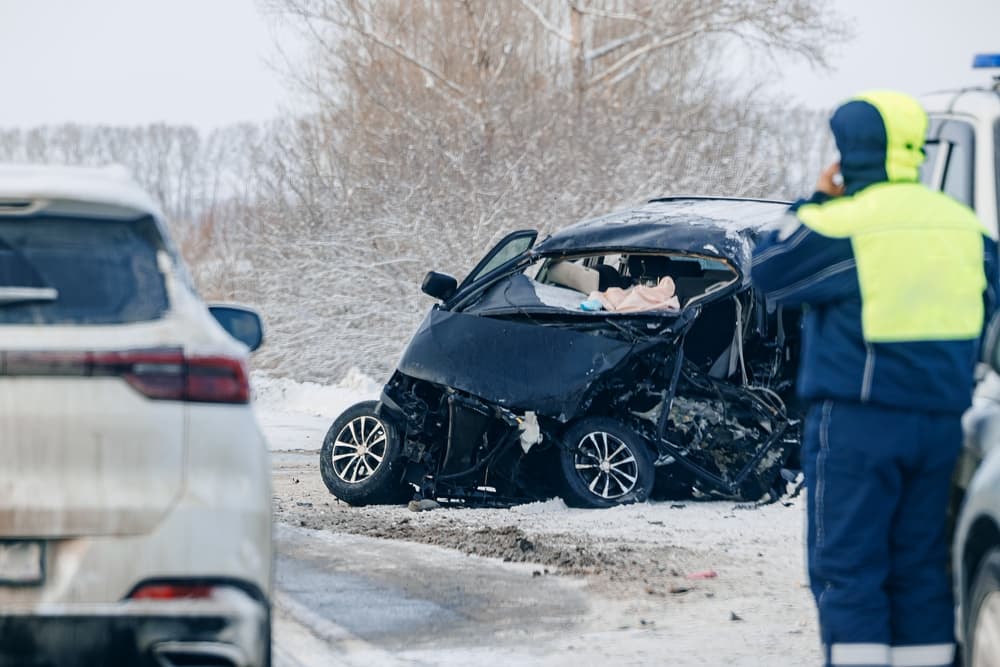 Winter driving accident in Morgantown showing a severe car crash on an icy, snow-covered road with emergency responders on scene